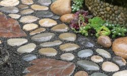 a-catchy-stone-garden-path-with-round-muted-color-stones-and-leaf-shaped-stones